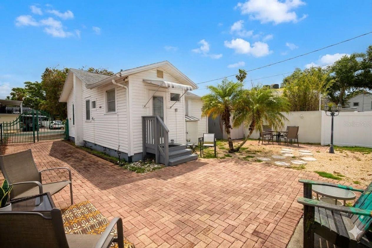 Large brick patio area out back with a shed