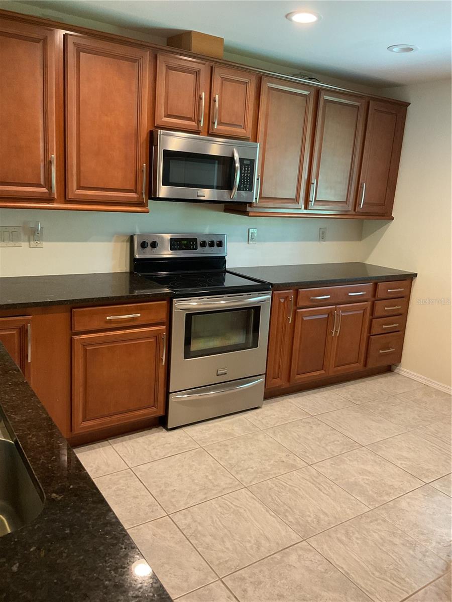 CHERRY WOOD CABINETS AND STAINLESS STEEL APPLIANCES