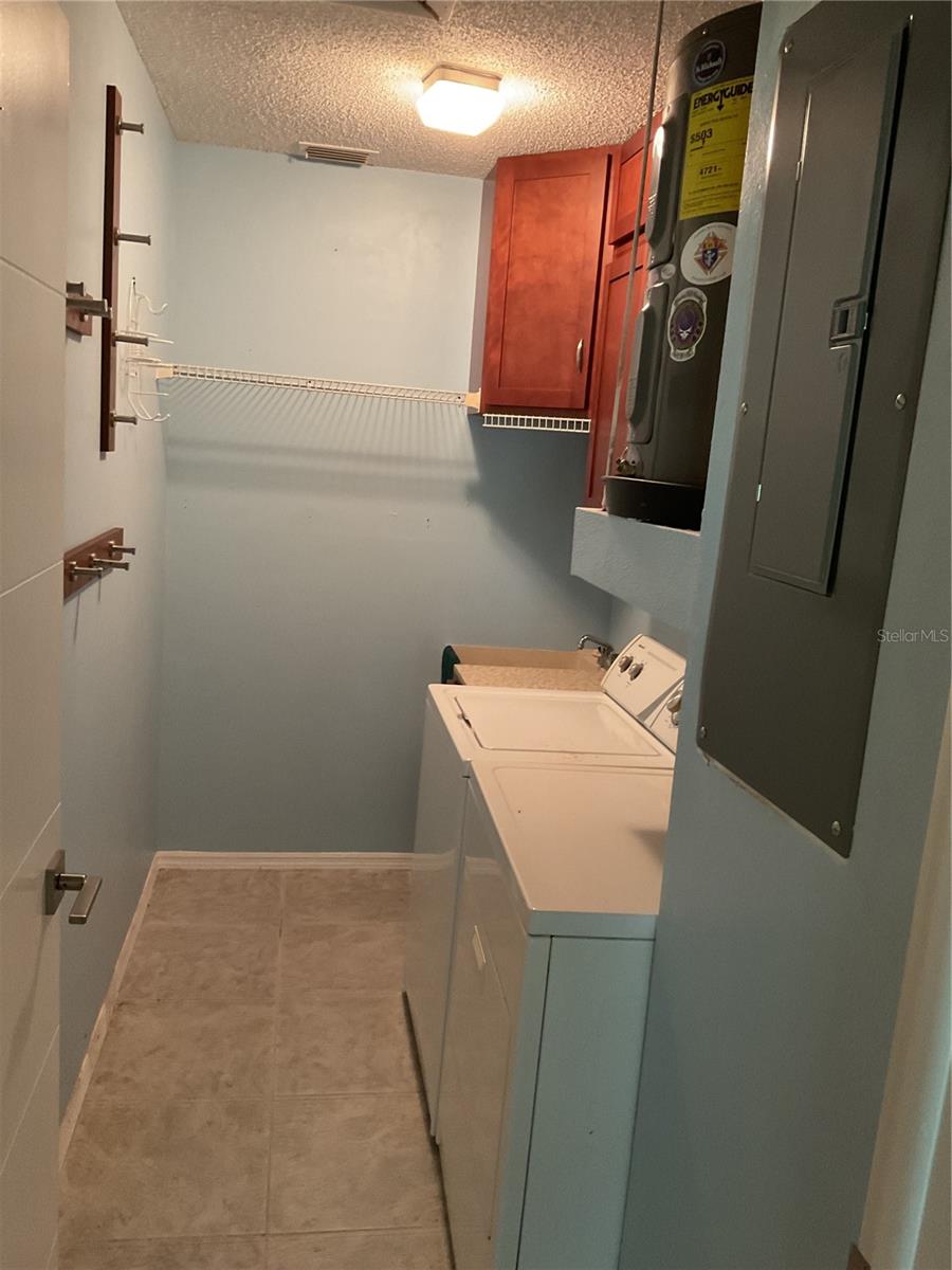 LAUNDRY ROOM WITH UTILITY SINK AND UPPER CABINETS.