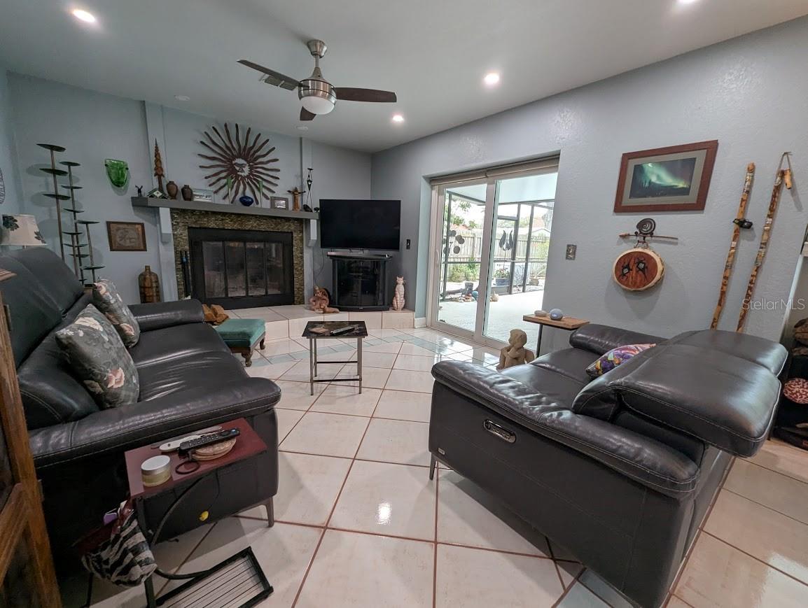 Family room has woodburning fireplace and pocketed doors leading to pool / spa area