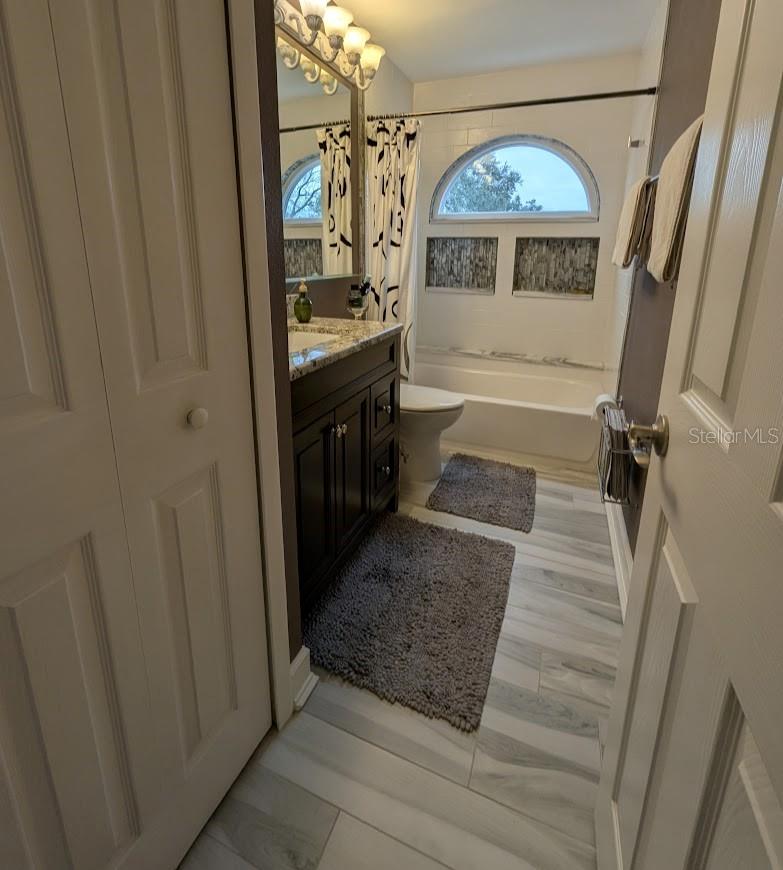 Remodeled hall bath with new tub, vanity, tile and lighting. Features linen closet