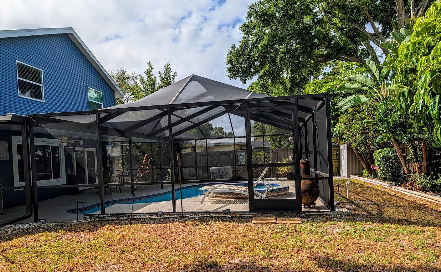 View of bird caged pool / spa / lanai