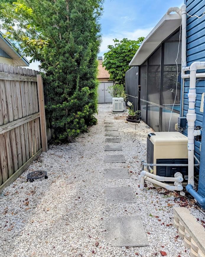 Utility side of house with view of pool equipment and whole house generator