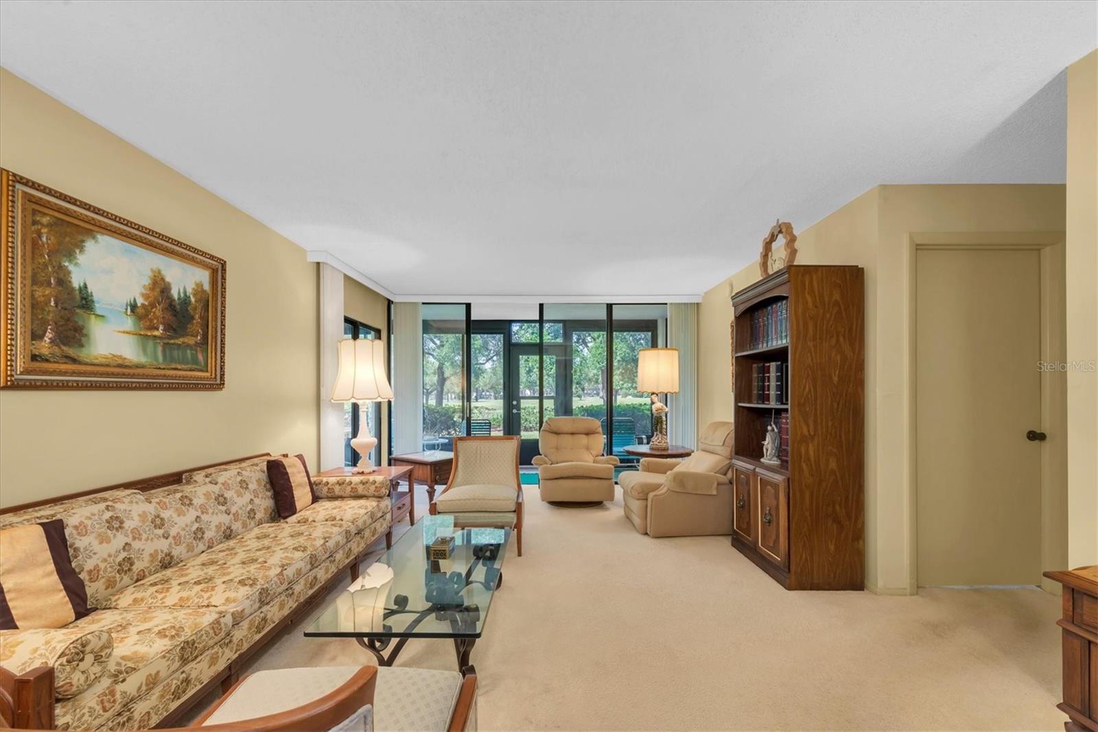 Living Room with a view to outside (Golf Course) and door to the rigtht opens to the Primary Bedroom