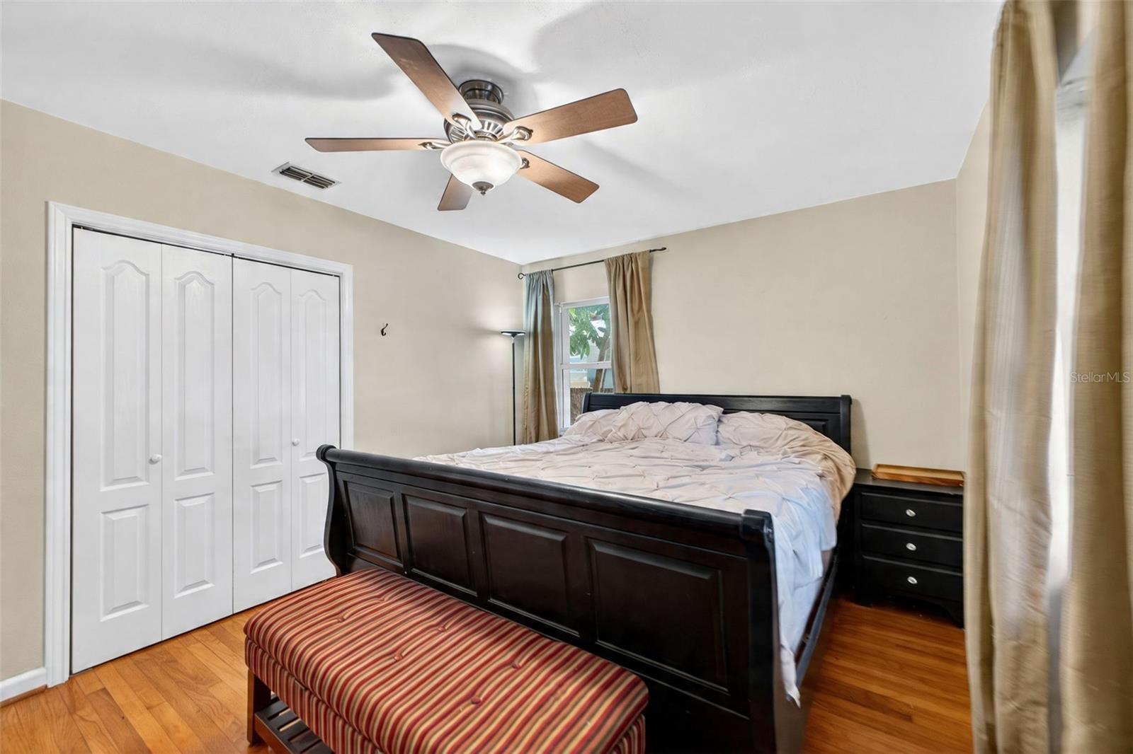 Primary bedroom has wood flooring and built in closet