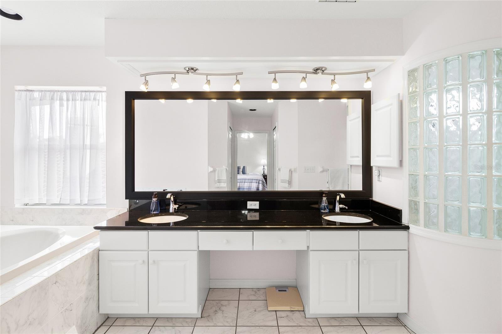 Primary bath with soaking tub, step in shower and his-and-hers closets and sinks.