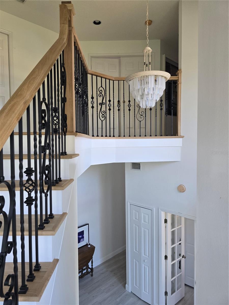 Graceful staircase overlooks foyer with gorgeous spindle patterns