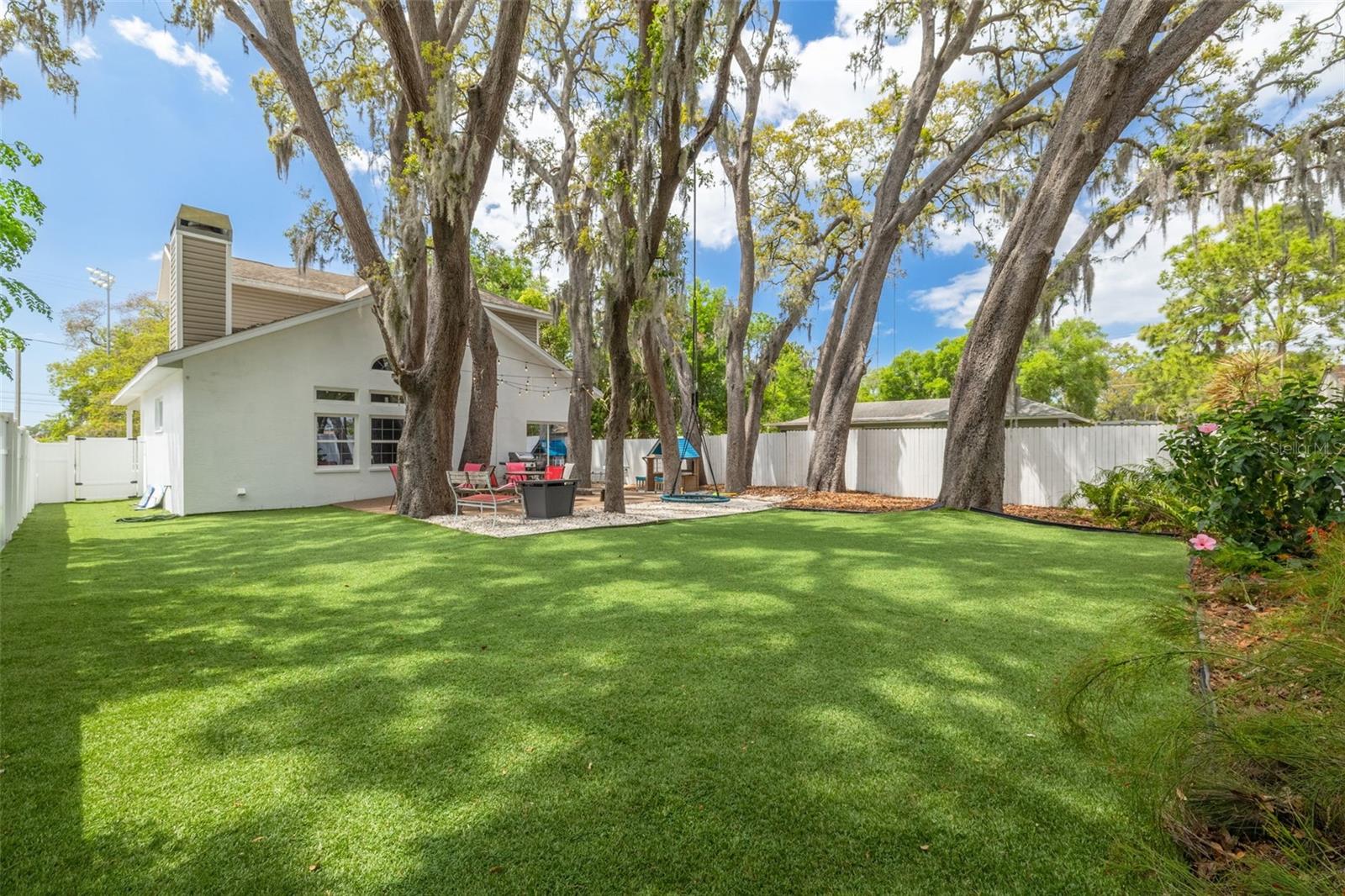 12 enormous live oak trees create a canopy over the oversized back yard, a beautiful setting for gathering all ages.