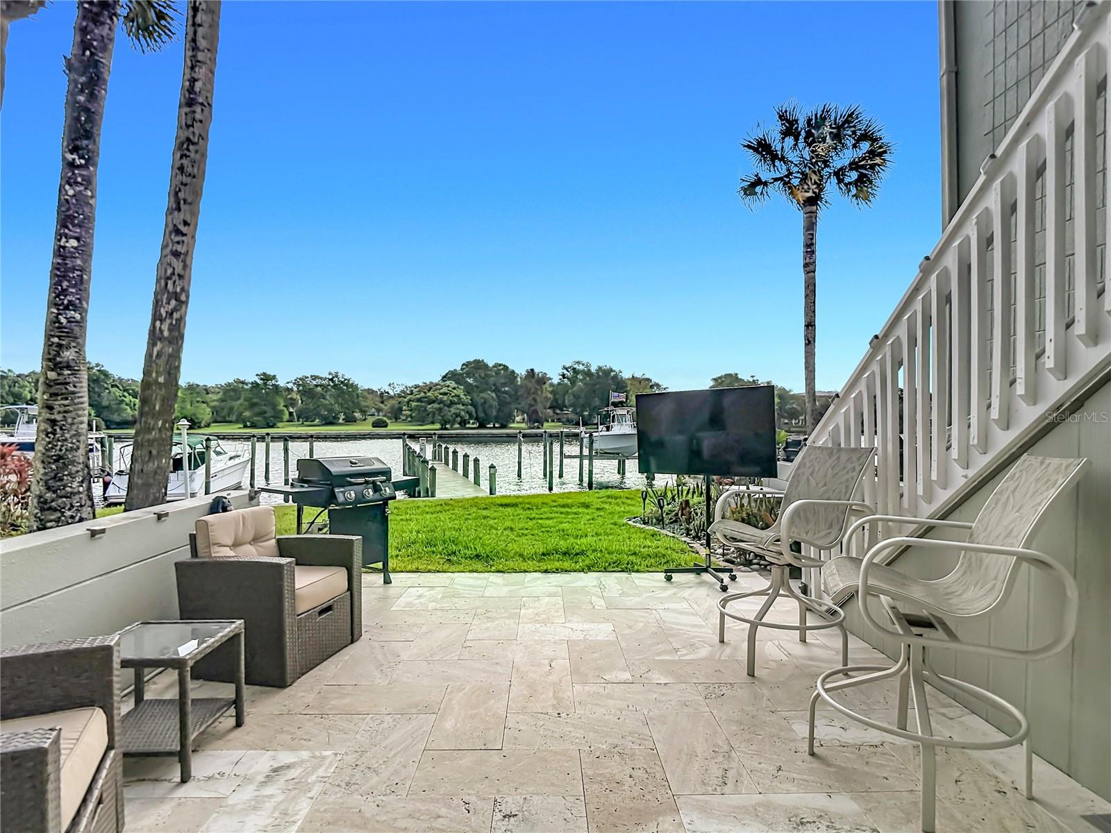 Spacious tile patio overlooking the water.