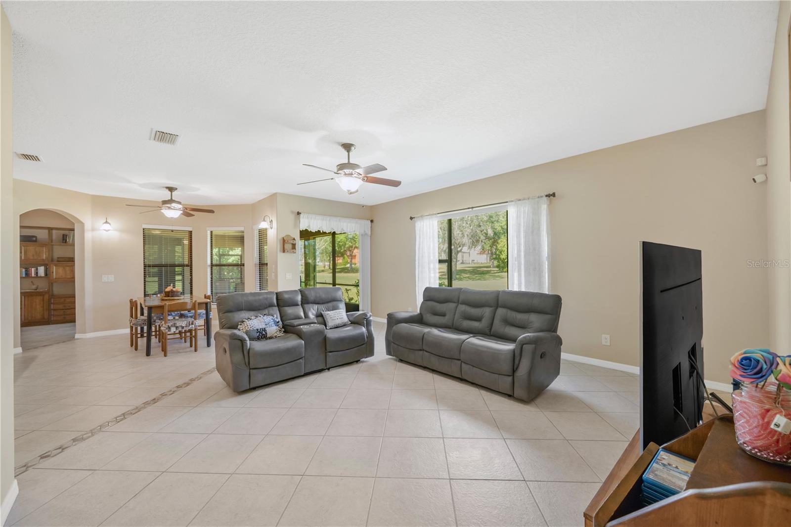 The spacious family room features a picture window with views of the lush, private backyard.