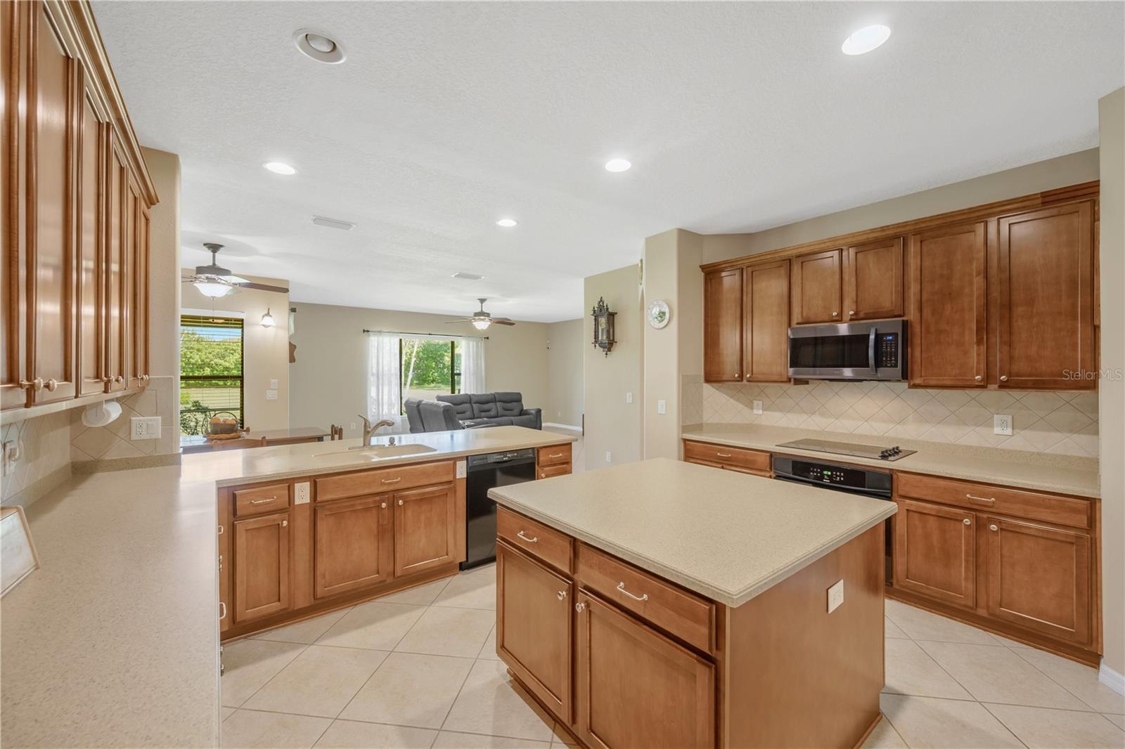 Corian countertops, abundant cabinetry, a large center island, and breakfast bar with seating.