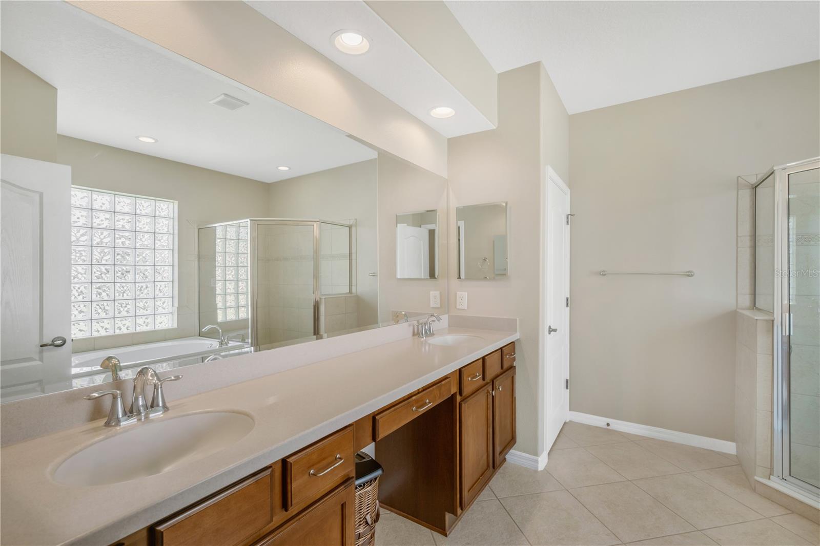 The primary suite features dual sinks and a spacious vanity, making busy mornings easy and convenient.