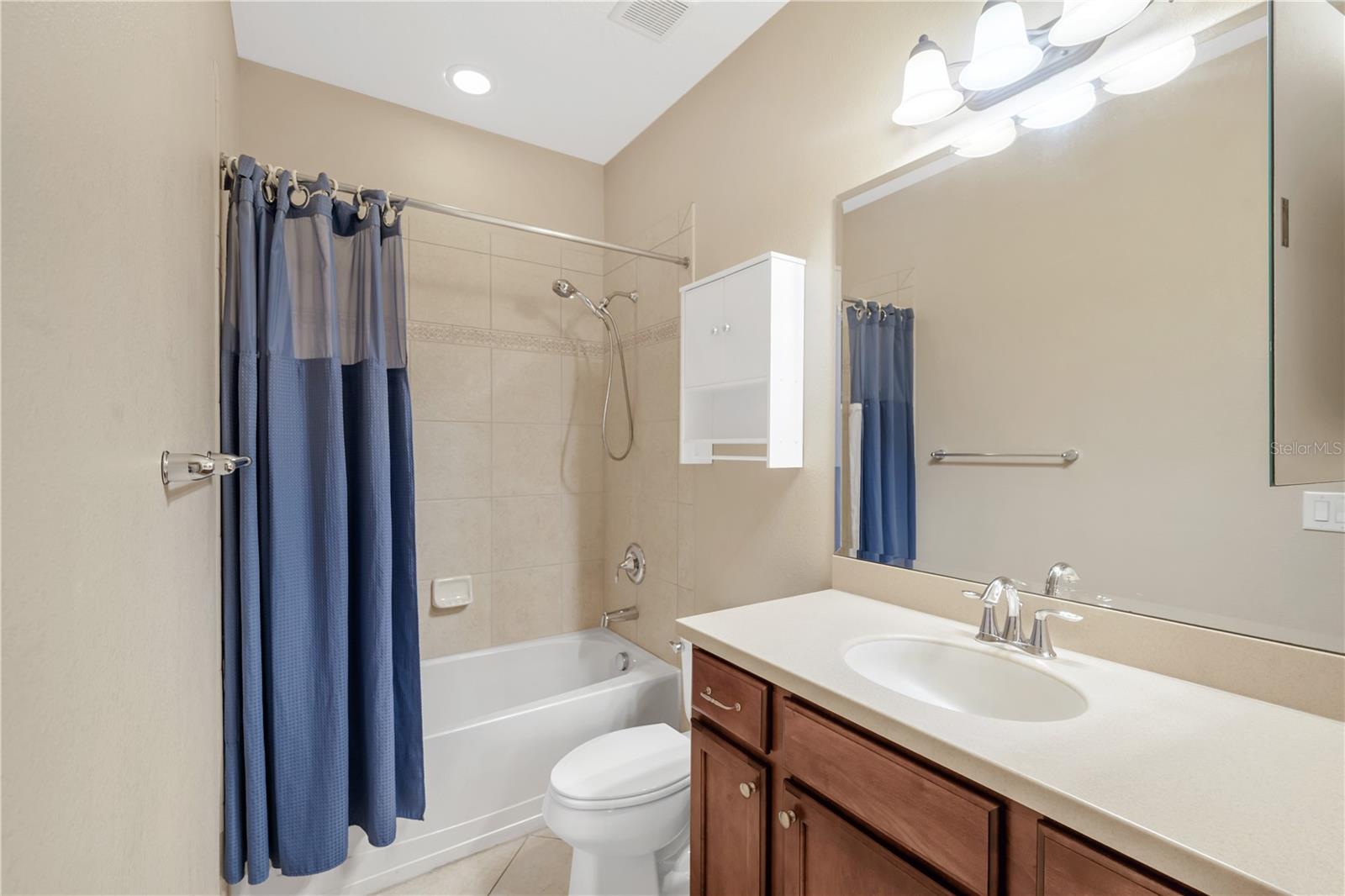 A full bathroom with a tub/shower combination is conveniently located in the hallway near the kitchen and family room, and is shared by two secondary bedrooms.