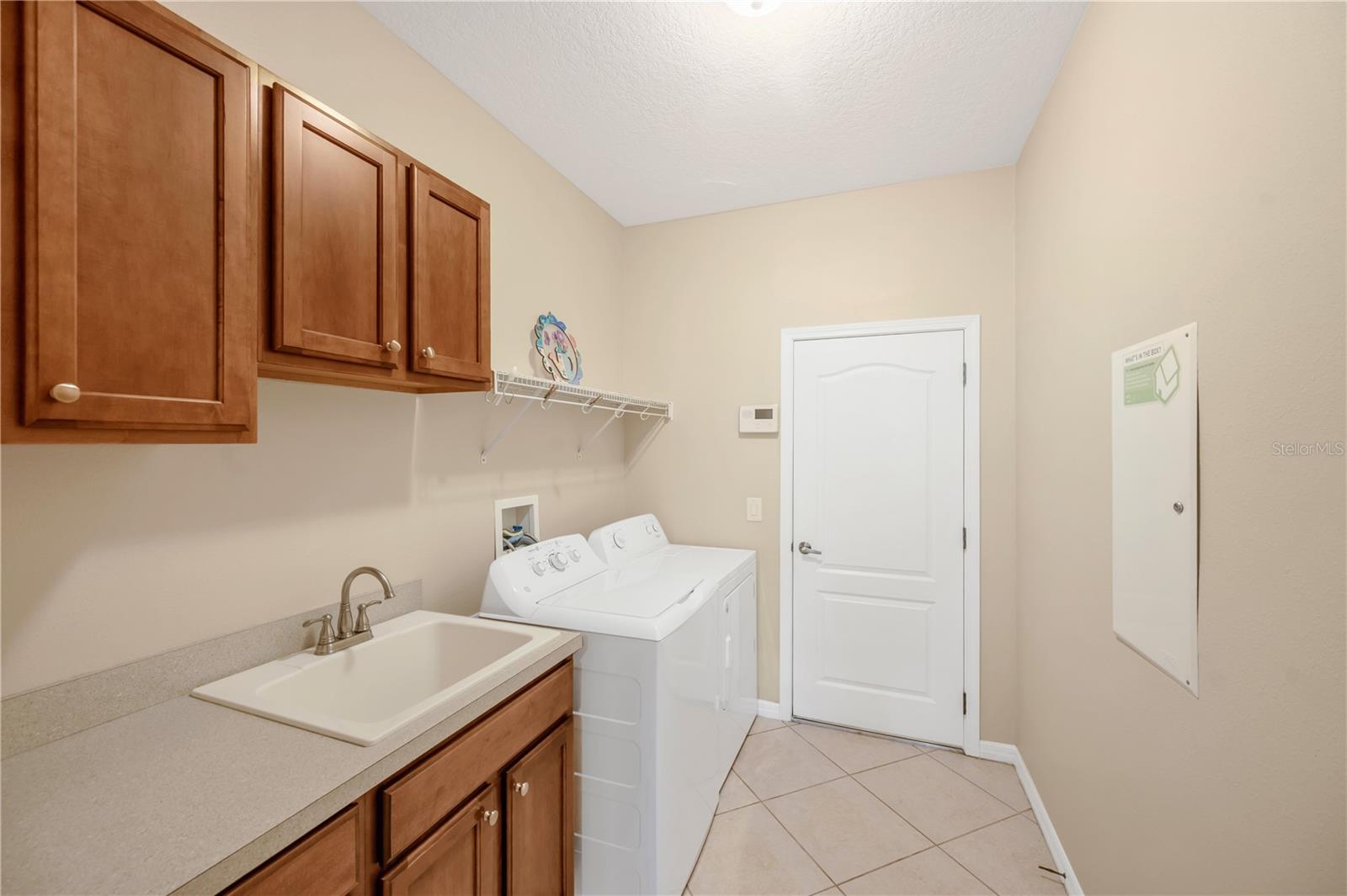 Just off the kitchen is a convenient laundry room featuring a separate utility sink and direct access to the 3-car garage. Washer and electric dryer do not convey to the buyer.