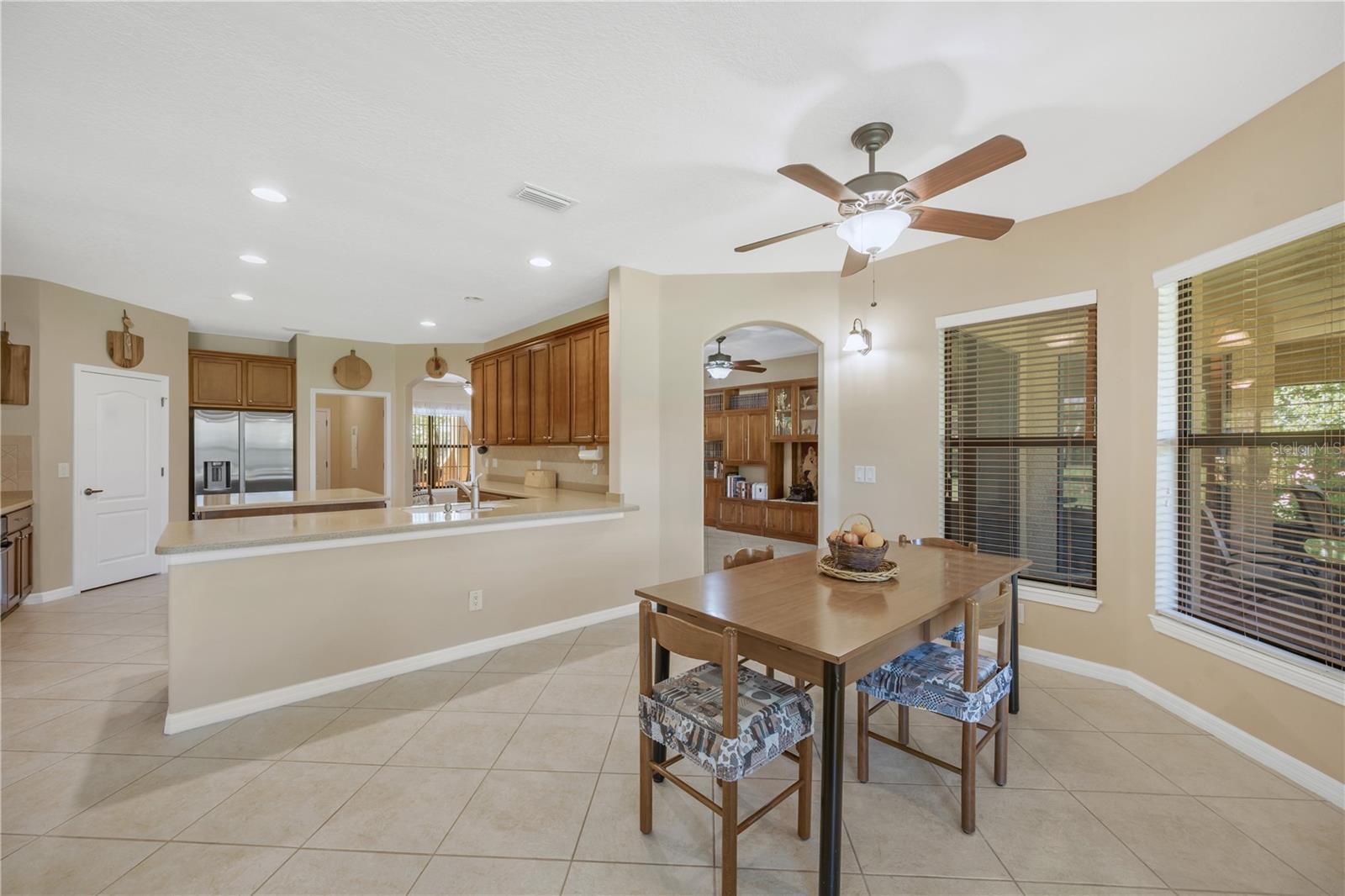 The eat-in area and kitchen workspace are connected by a single-level counter with the kitchen sink, creating an easy flow for entertaining and providing additional seating options when guests gather.