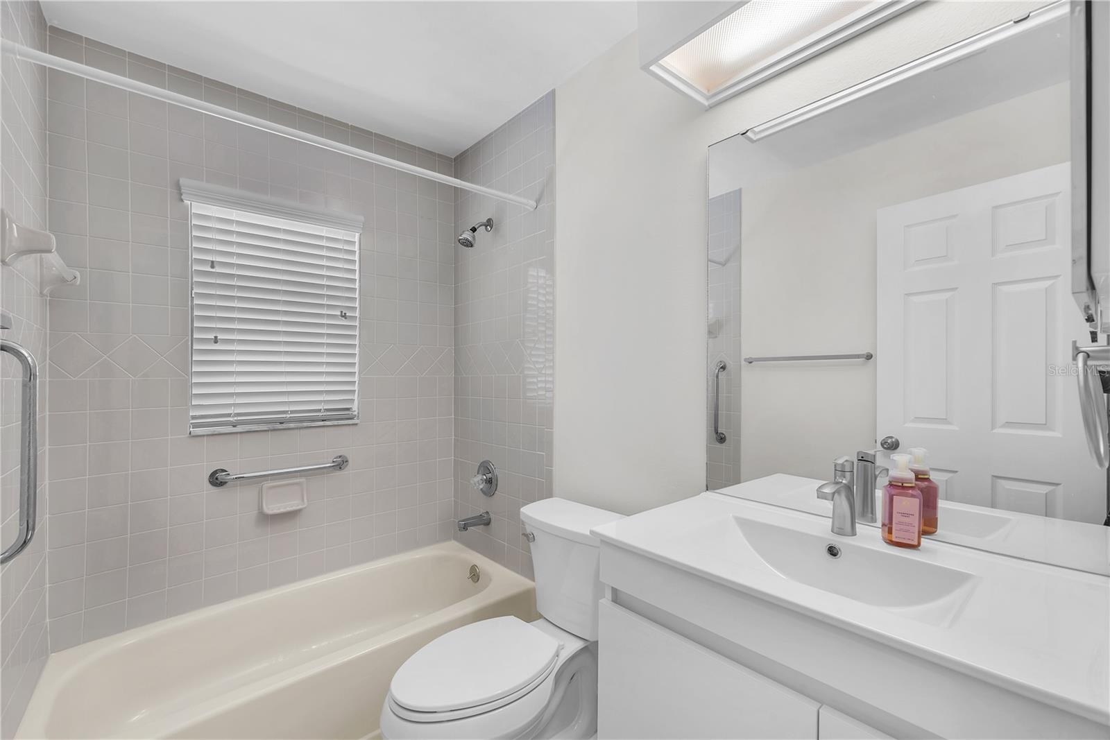 Guest bathroom has a bath tub/shower combination.