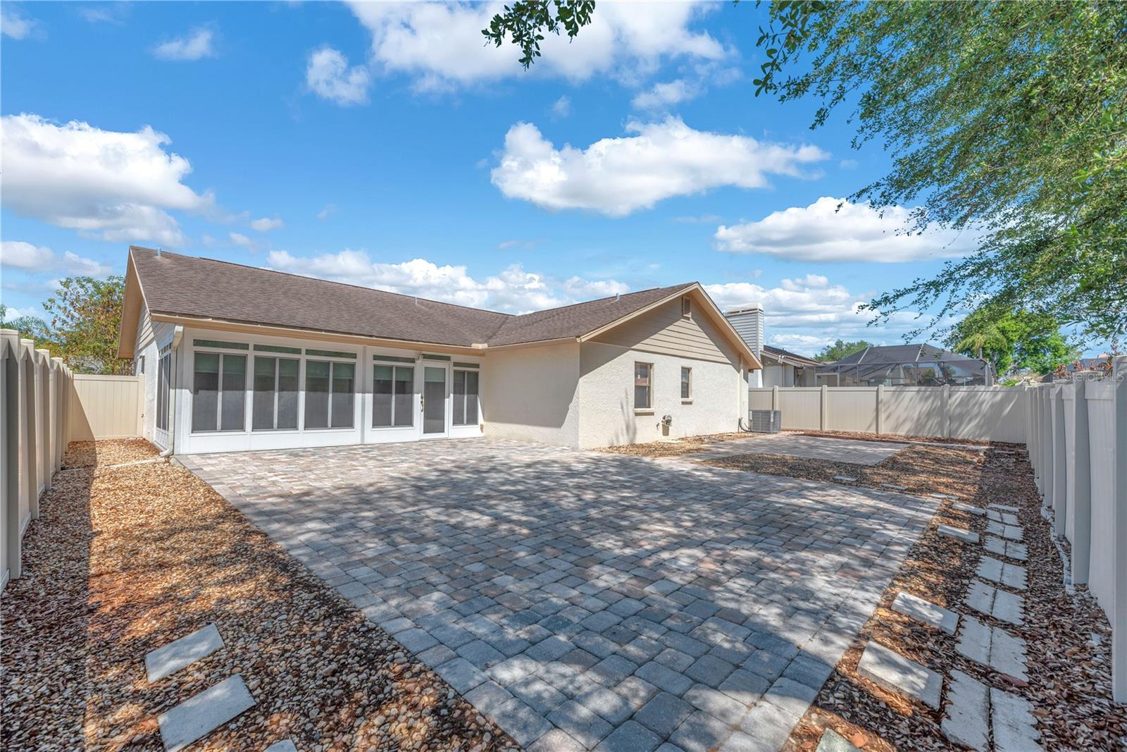 Step outside to enjoy a low-maintenance backyard retreat perfect for outdoor entertaining with this enormous paver patio and additional concrete patio, all framed by attractive stone borders.