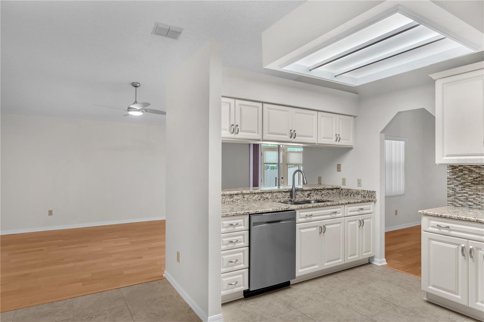 Linen-colored cabinetry, stainless steel appliances, and a breakfast bar overlooking the family room is perfect for casual meals or entertaining.