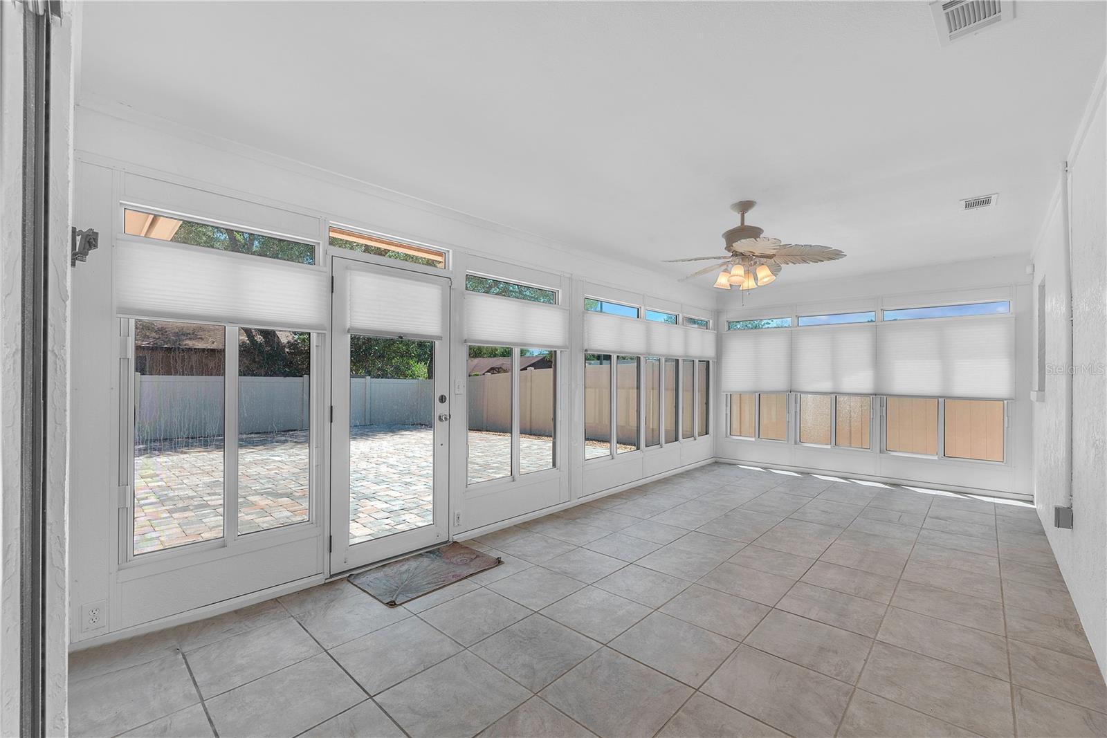 The enclosed and air conditioned florida room is an ideal extension of your living space overlooking the fenced backyard and spacious pavered patio.