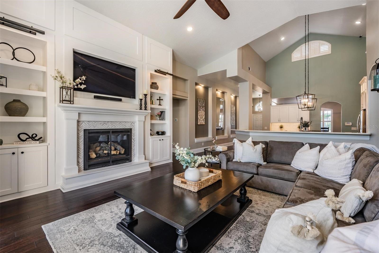 The fireplace has a raised hearth and is flanked by built-ins