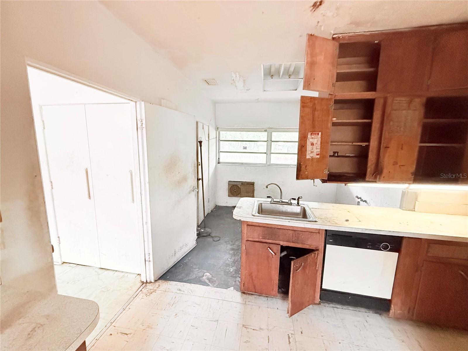 Additional kitchen angle showcasing abundant cabinet storage, built-in oven area, and open sightlines to the living space. Strong potential for an open-concept remodel.