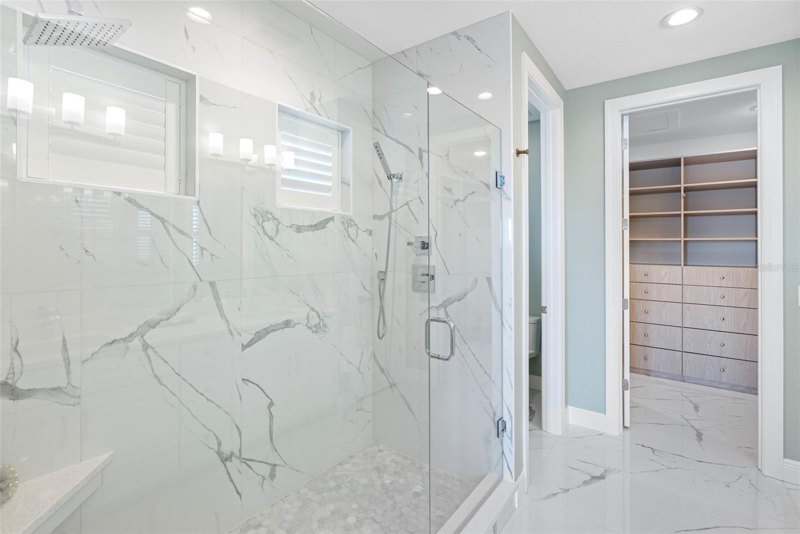 Spacious walk-in shower with dual shower heads and glass shower enclosure