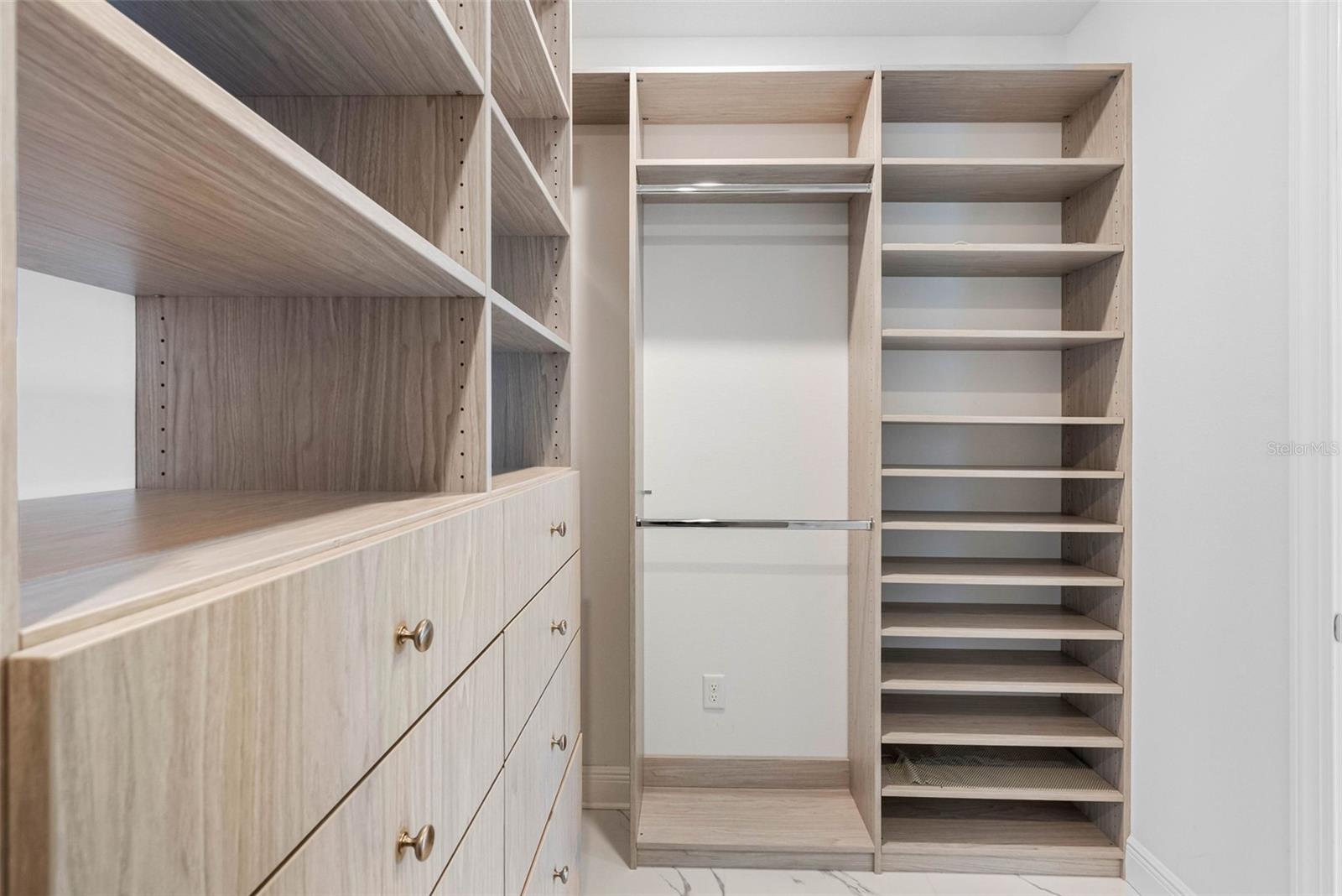 Walk-in closet features built-in organizer with drawers and shelving