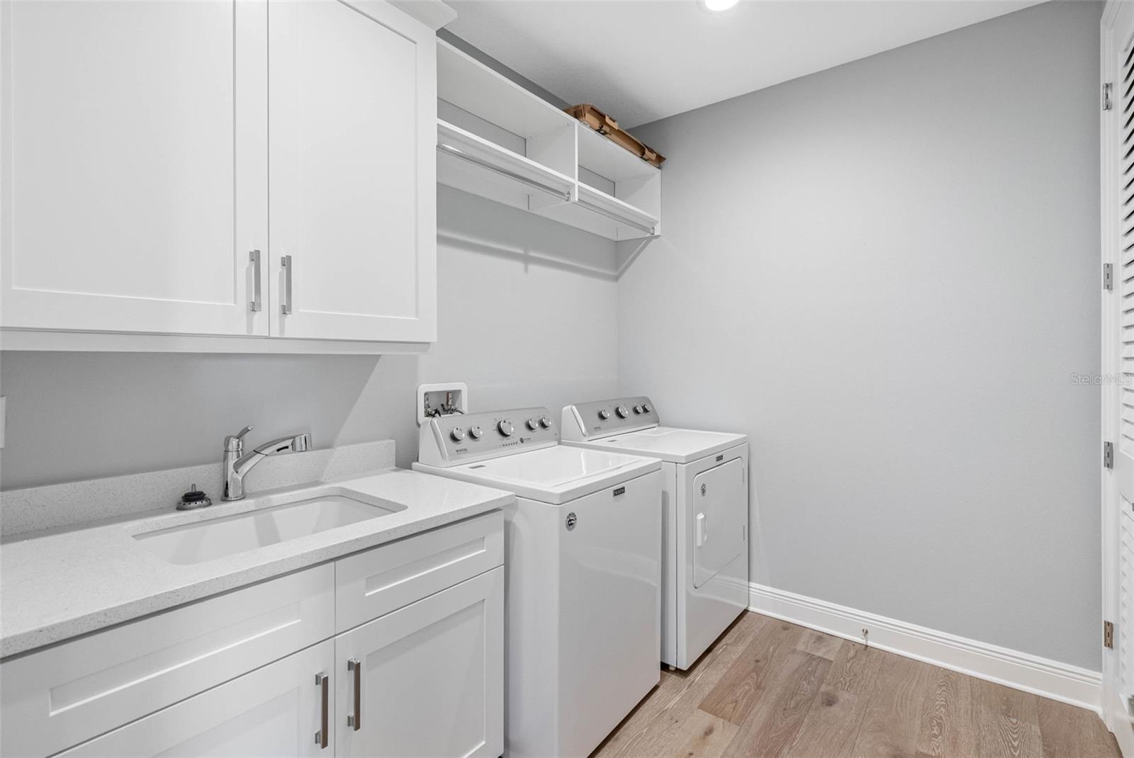 Laundry room with utility sink and cabinetry