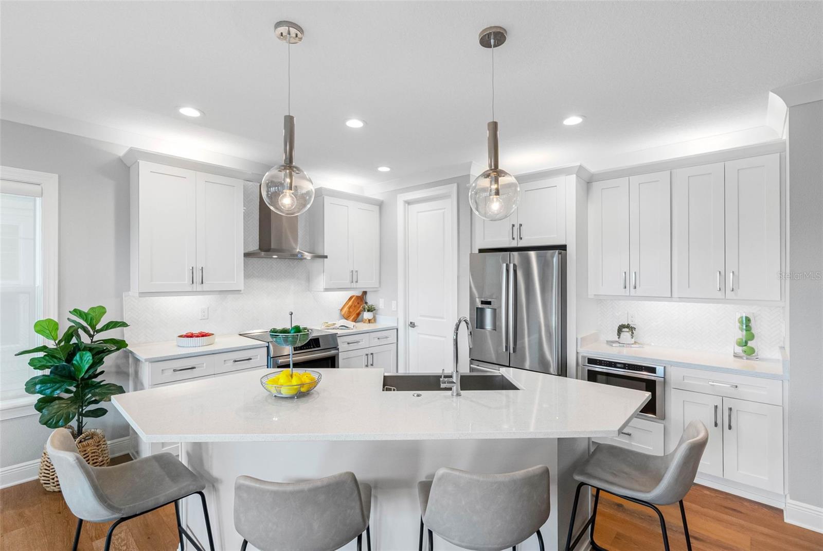Kitchen Island has plenty of seating area and beautiful pendants