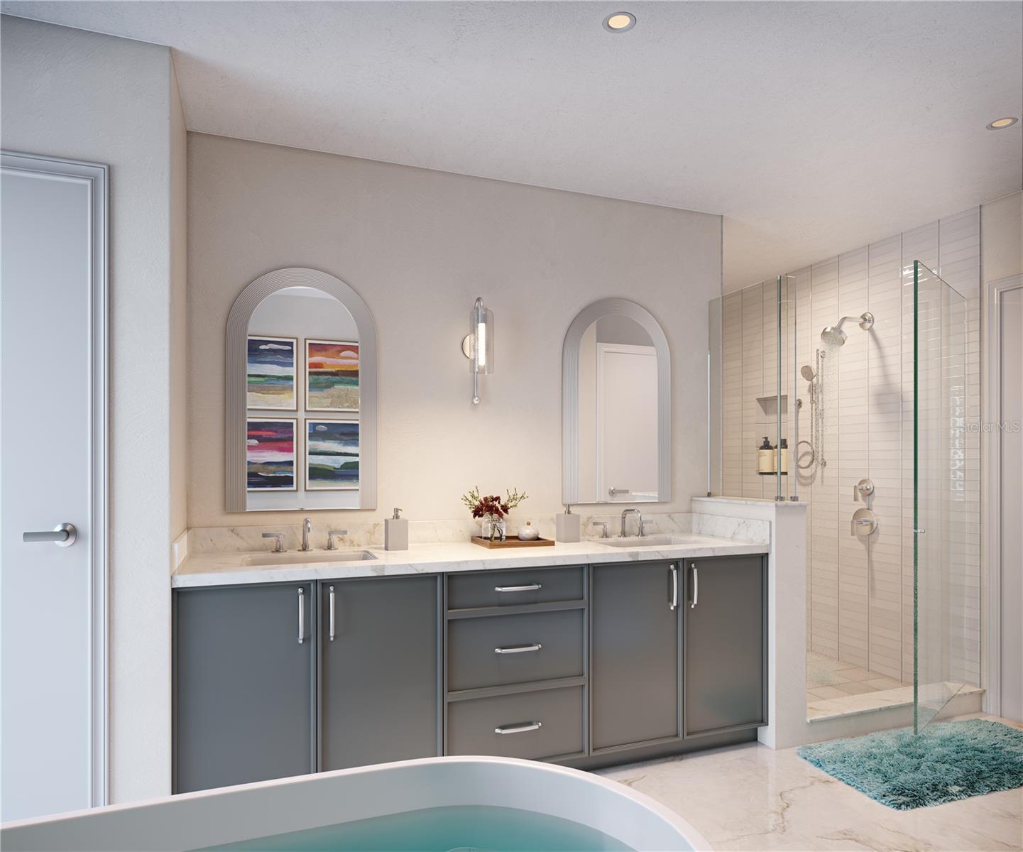 Primary bathroom featuring double vanity, free standing tub, walk in shower and spacious walk in closet