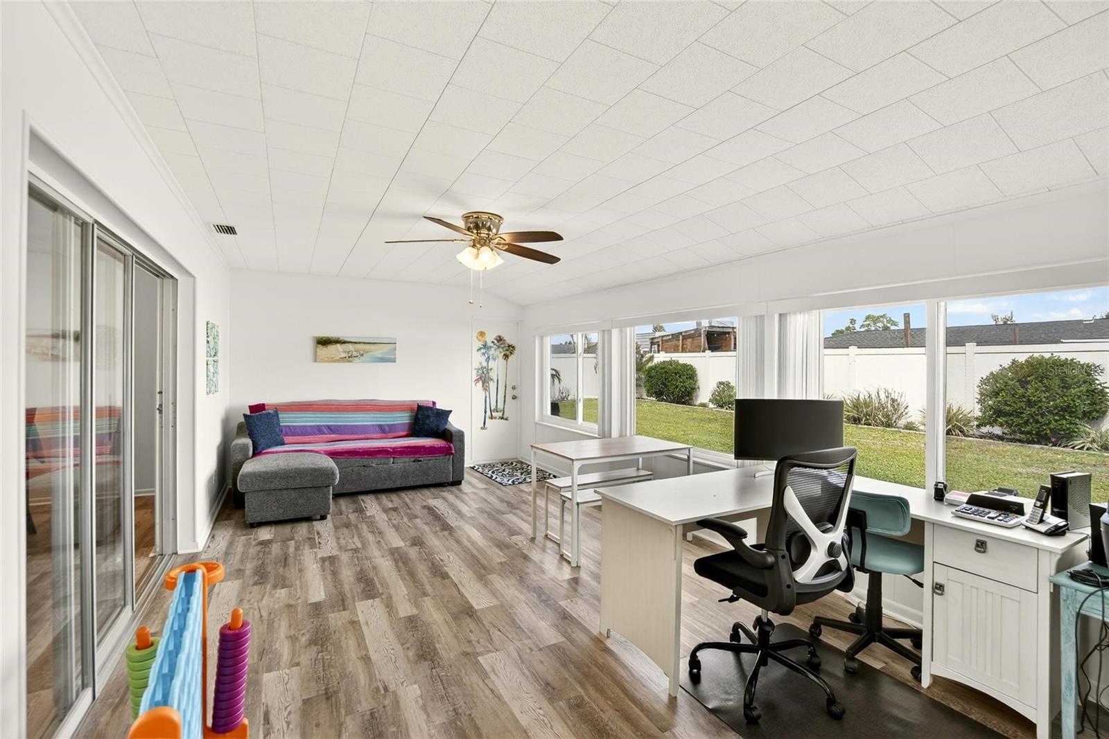 The Florida Room with large windows and sliding glass doors that allow the space to be bright and cheerful