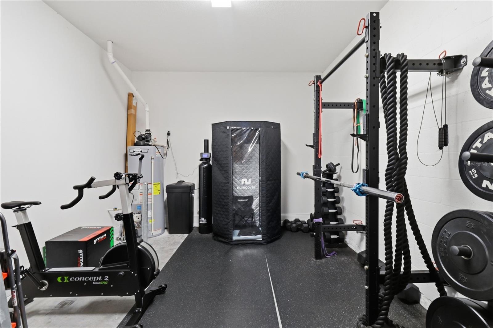Tandem garage currently used as a home gym with plenty of room for storage, hobbies, or extra parking.