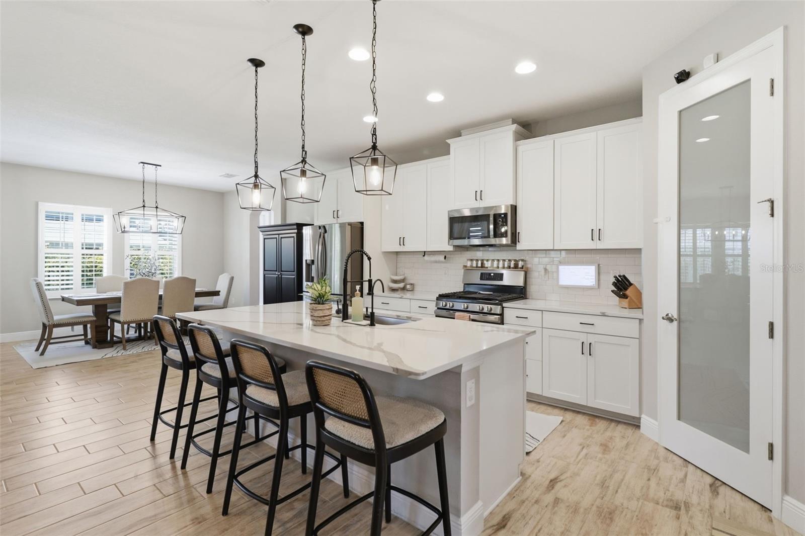 Open kitchen with breakfast bar seating, gas stove, and seamless flow into the dining area.