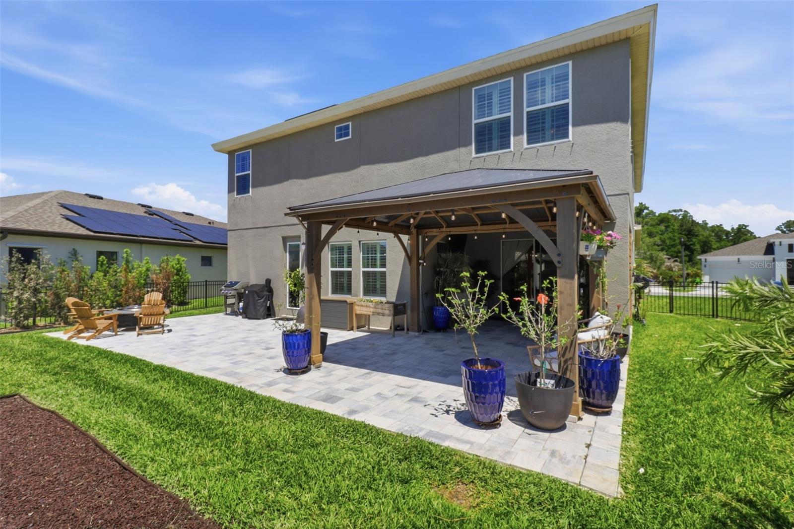 Outdoor paved seating area with a gazebo overlooking the playground—perfect for relaxing or entertaining.