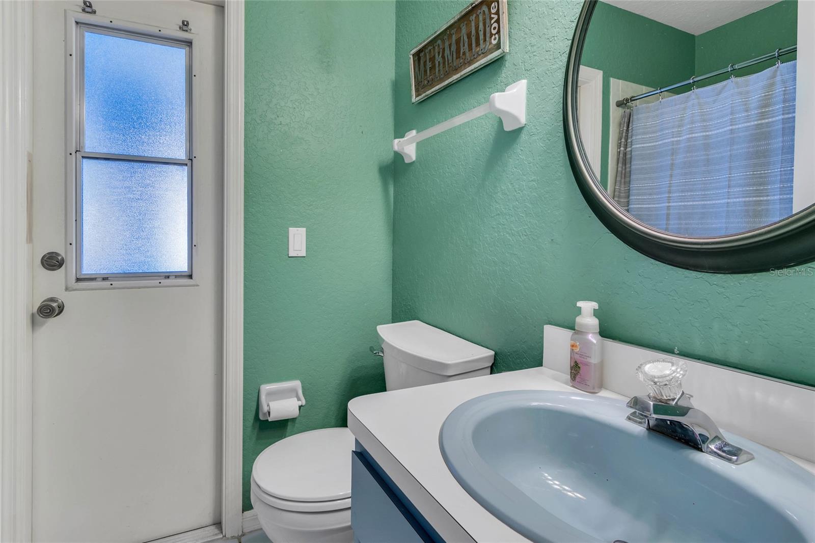 Bathroom 2 with doorway to pool deck