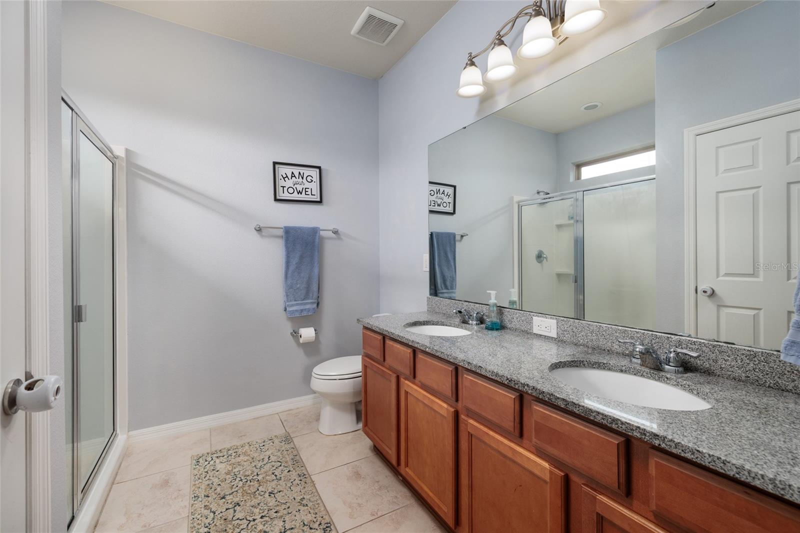 Primary Bath - granite countertop vanity with dual sinks, and roomy shower.