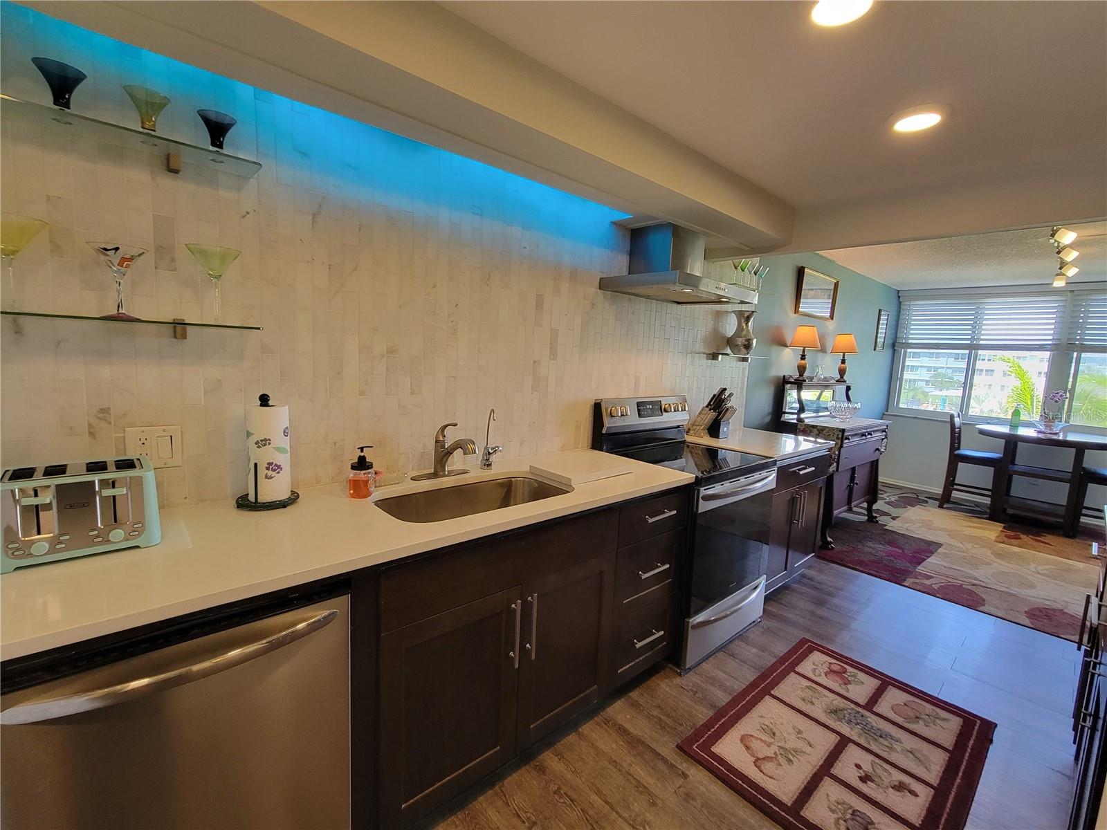 Generous counter space with full marble tile backsplash and indirect lighing.