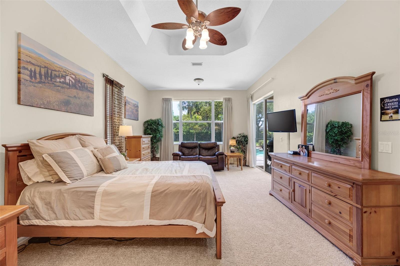 The Primary Bedroom features brand new carpet in April 2026, a tray ceiling, and a glass slider to the pool and jacuzzi.