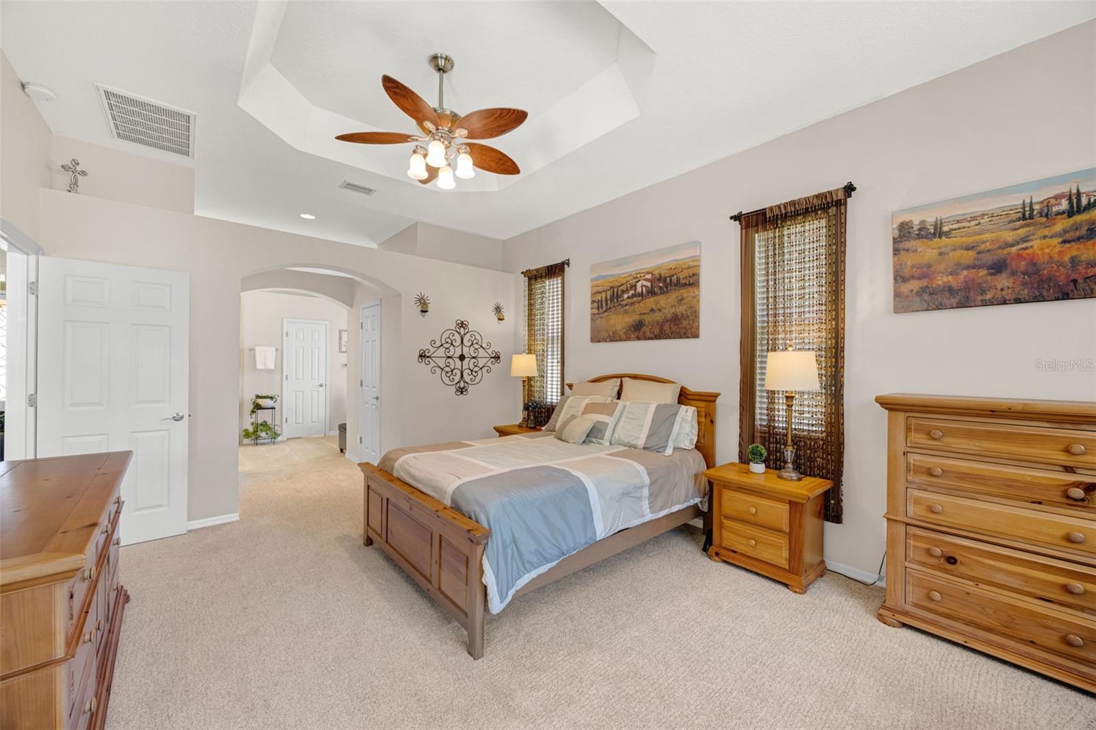 Primary Bedroom features brand new carpet in April 2026, a tray ceiling, and a glass slider to the pool and jacuzzi.
