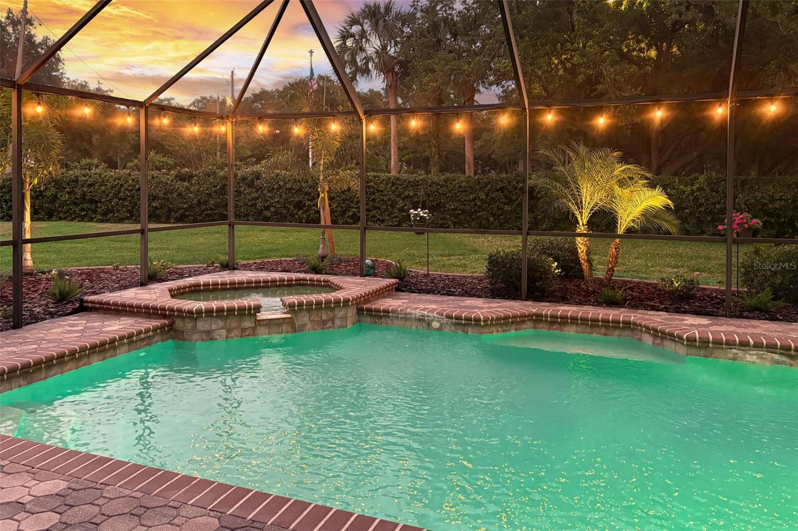 A beautiful evening in your own very private backyard.  POOL and JACUZZI with waterfall and fountains with a brick-paver lanai.