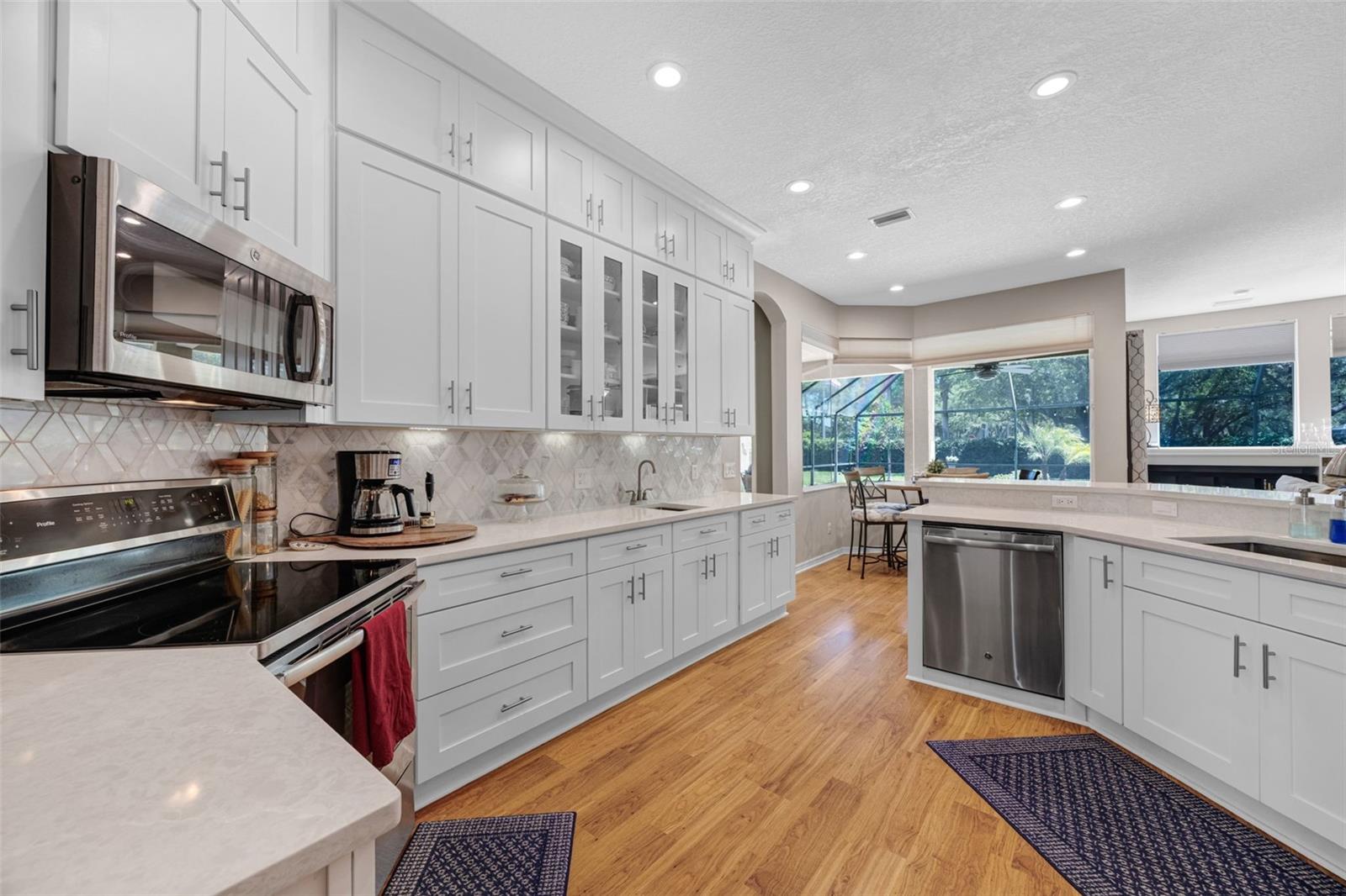 A Chef's Dream Kitchen! Quartz countertops, floor-to-ceiling cabinets, tiled backsplash, two sinks, and newer stainless appliances.
