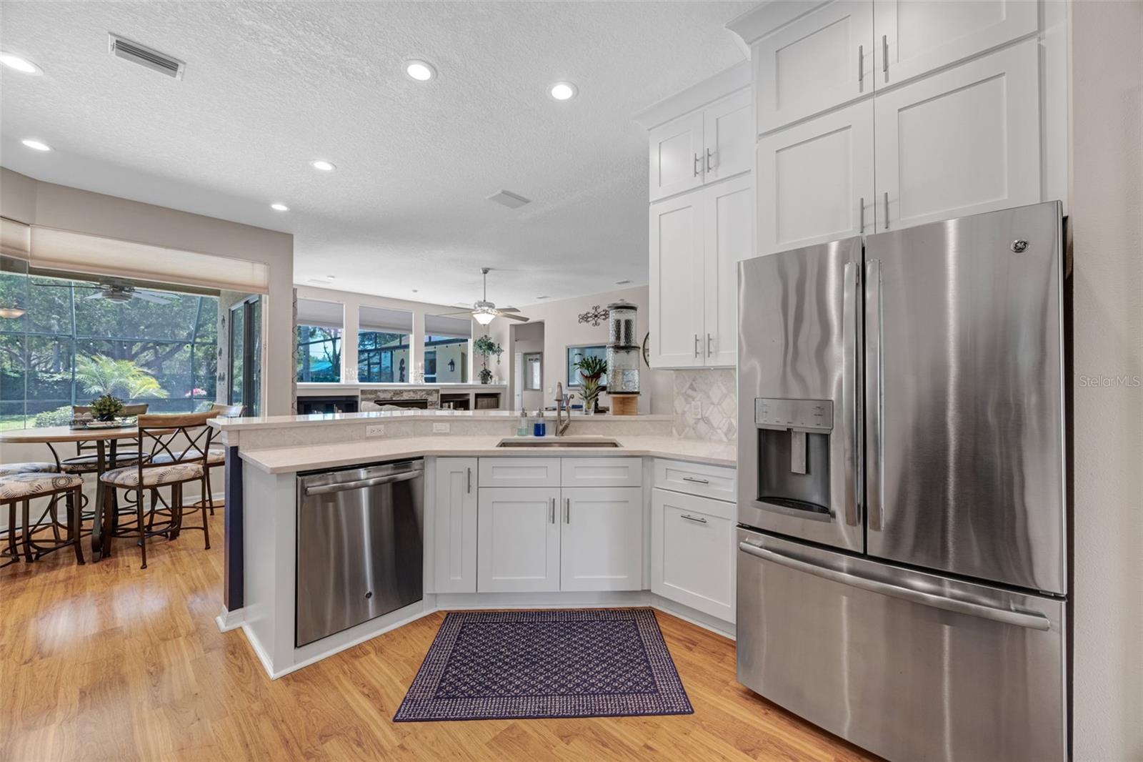 A Chef's Dream Kitchen! Quartz countertops, floor-to-ceiling cabinets, tiled backsplash, two sinks, and newer stainless appliances.
