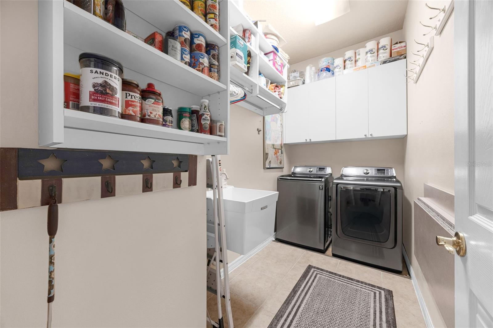 The Laundry Room has a sink, overhead cabinets, and lots of storage space.