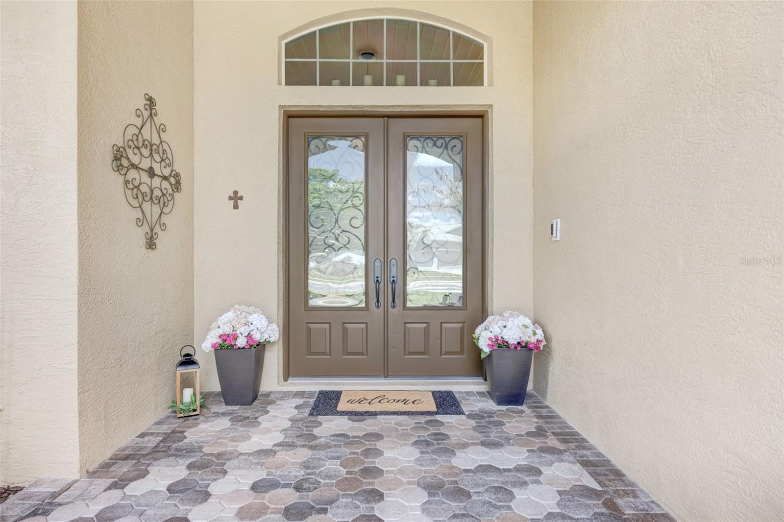 Beautiful 8-foot doors with glass and embedded rod iron design, plus a transom window above for added natural light.