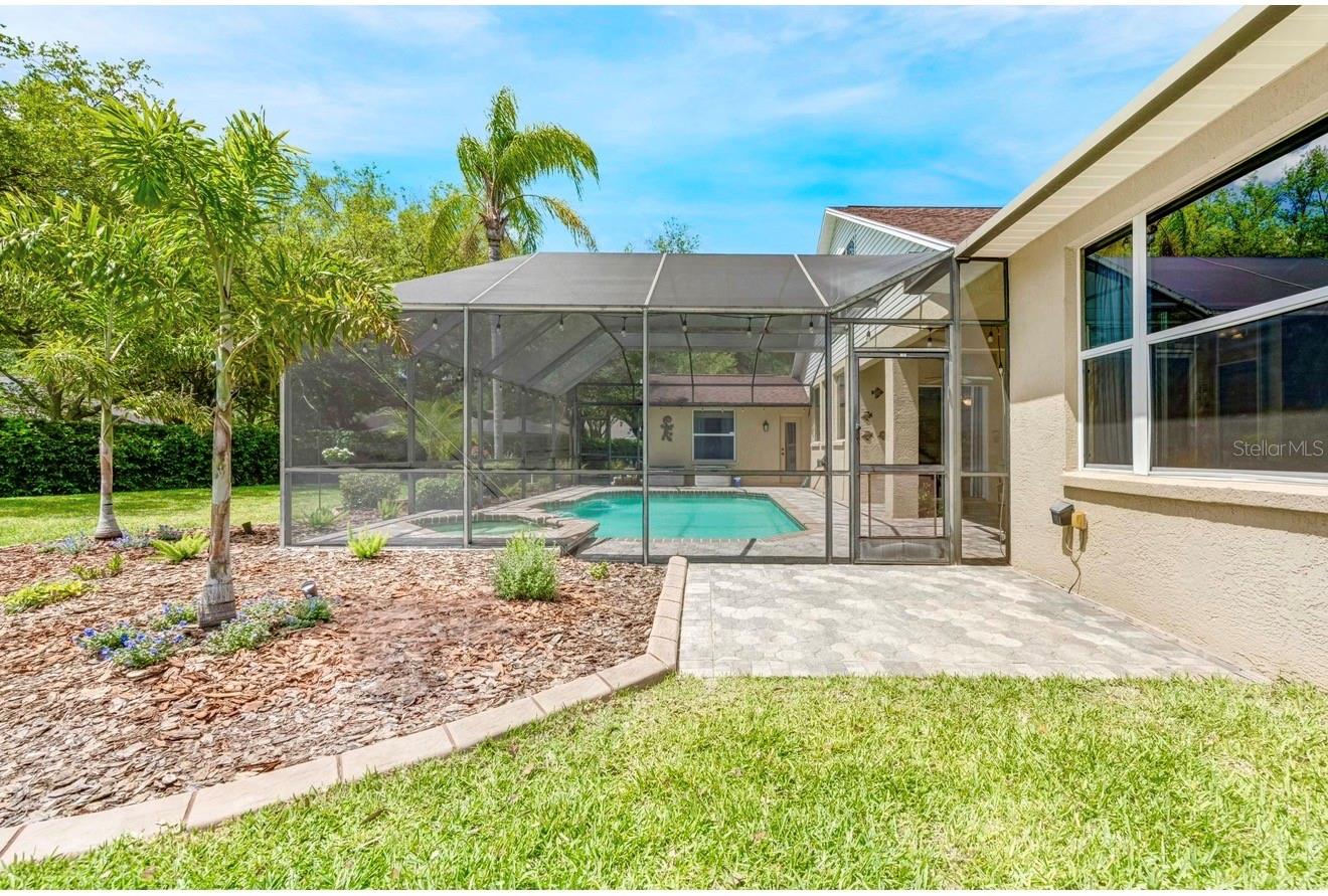 A pavered patio just outside the screened area is perfect for grilling or lounging in the sun.