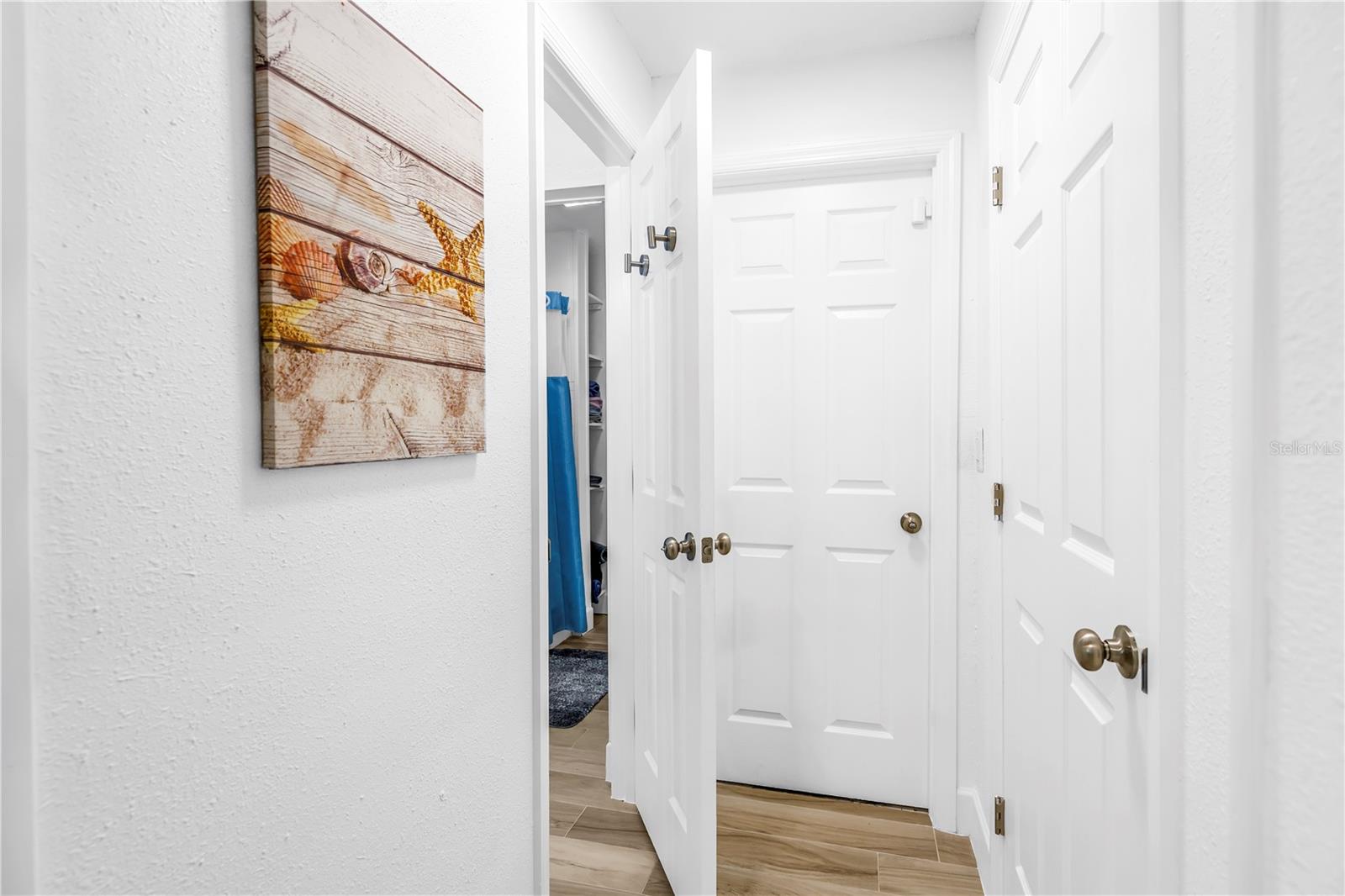 Hallway off kitchen leads to bath, panty and access to garage area