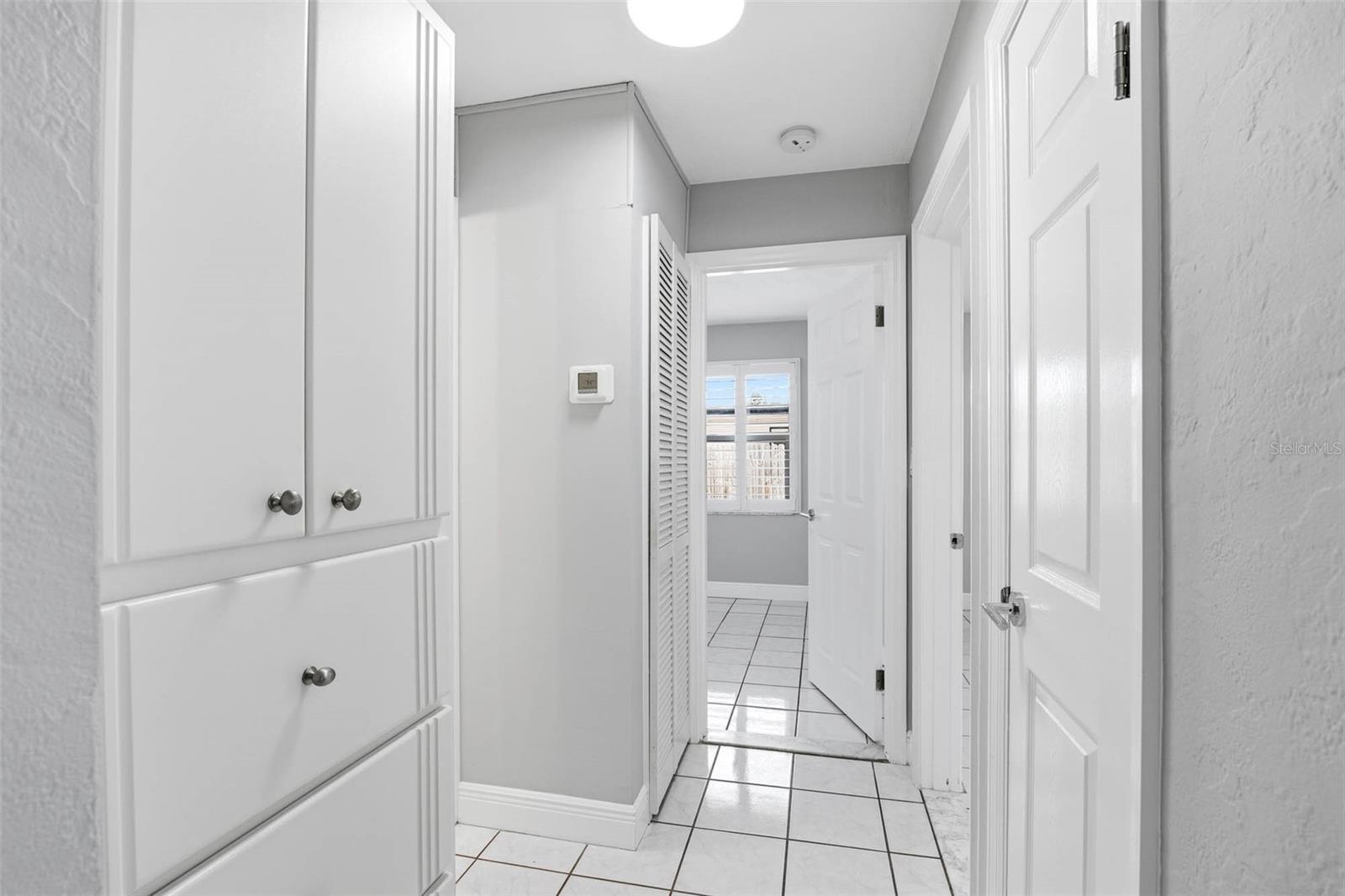 Hallway with linen closet and built-in cabinet and drawers