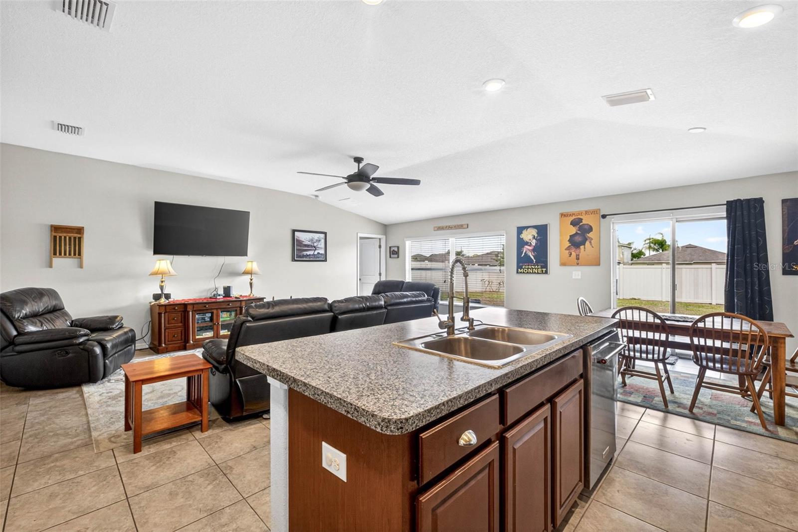 Kitchen/living/dining combination with views of the fully fenced back yard
