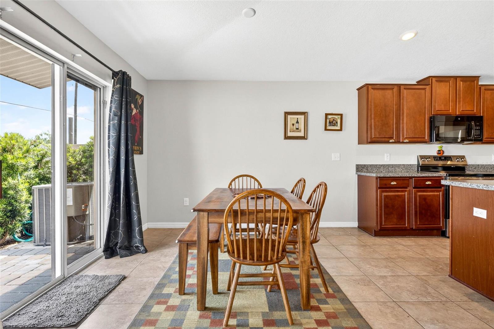 Dining room with sliding glass doors overlooking the pavered patio and fully fenced back yard.