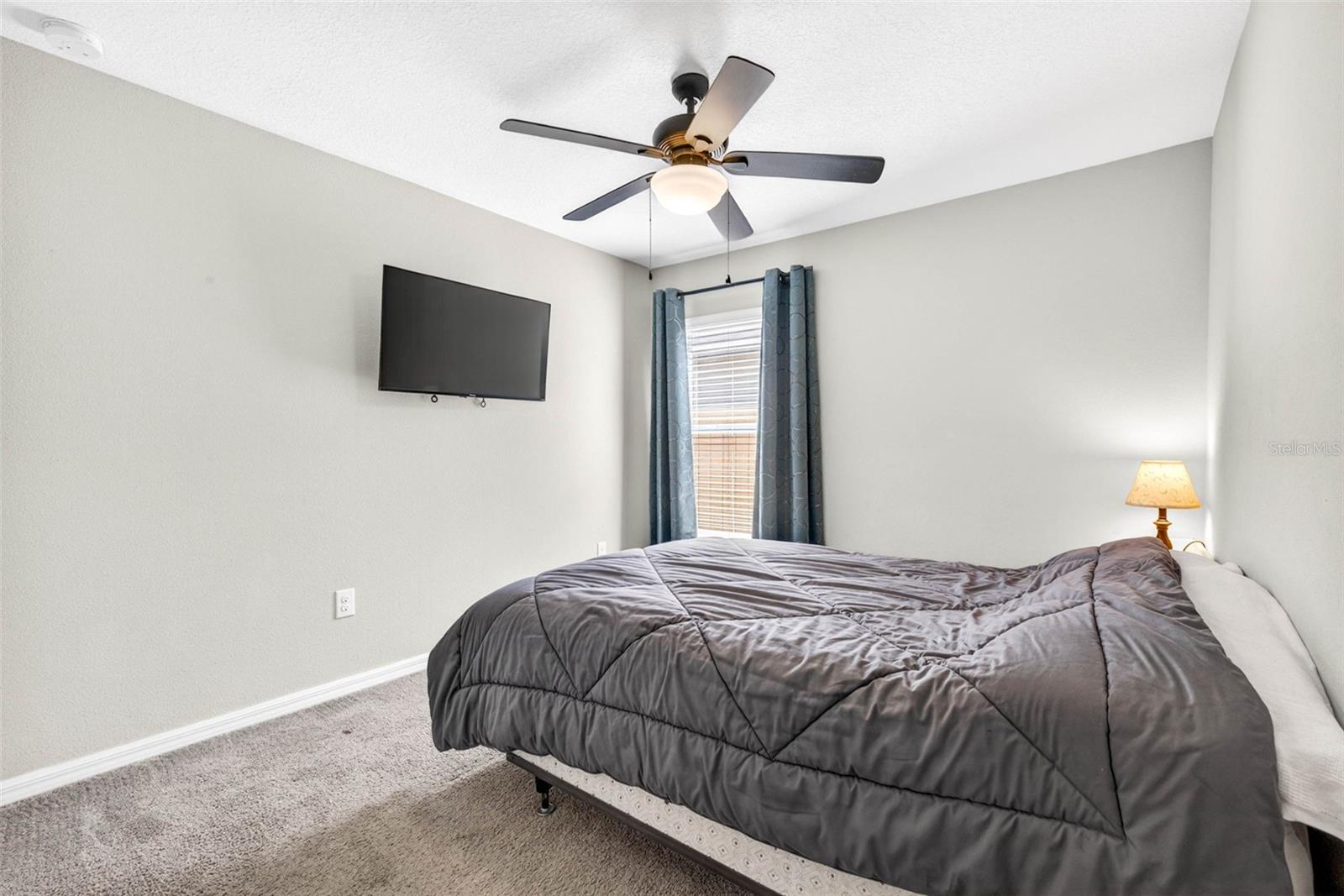 Secondary bedroom with ceiling fan and blinds.
